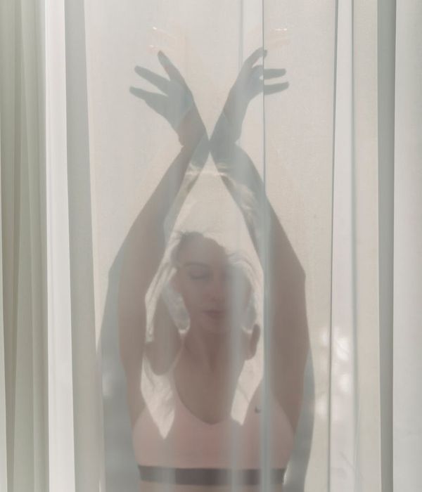 Woman meditating in a peaceful yoga pose, bathed in soft light.
